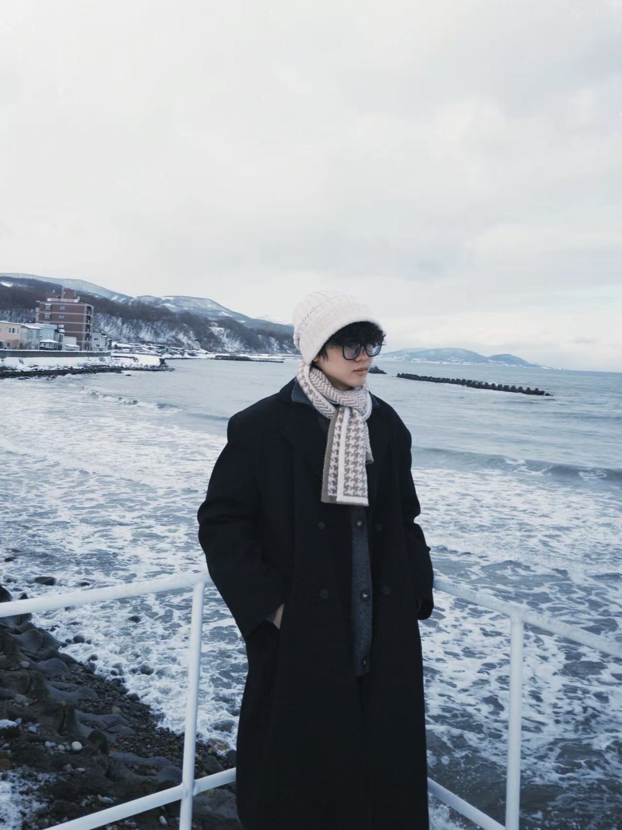 Zev standing by a snowy seaside